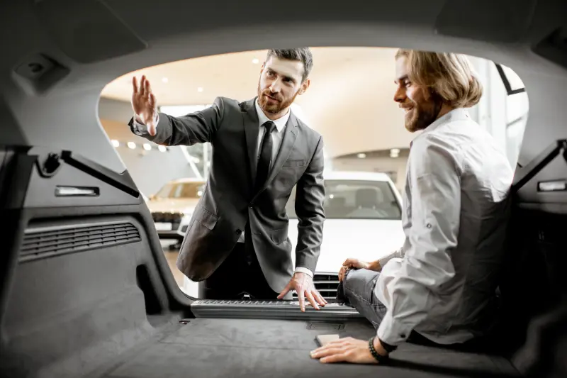 Pareja de hombres viendo el maletero de un cuv crossover de ocasión