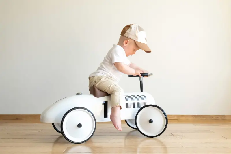 Bebé conduciendo un coche utilitario de juguete