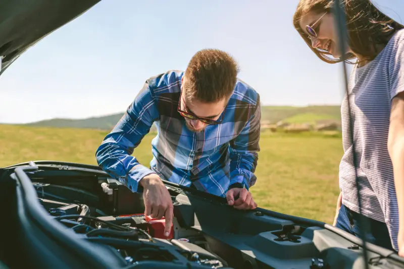 Personas revisan el motor del vehículo