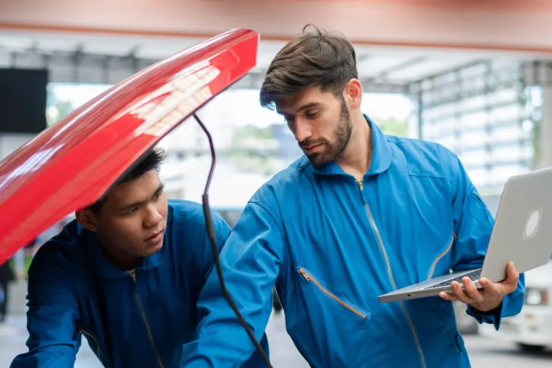 Mecánicos revisando un coche de segunda mano